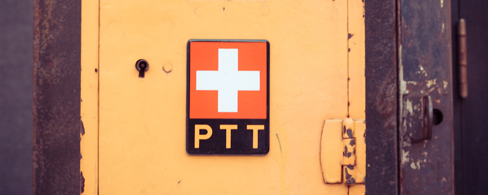 Altes Logo der PTT an einem alten Briefkasten